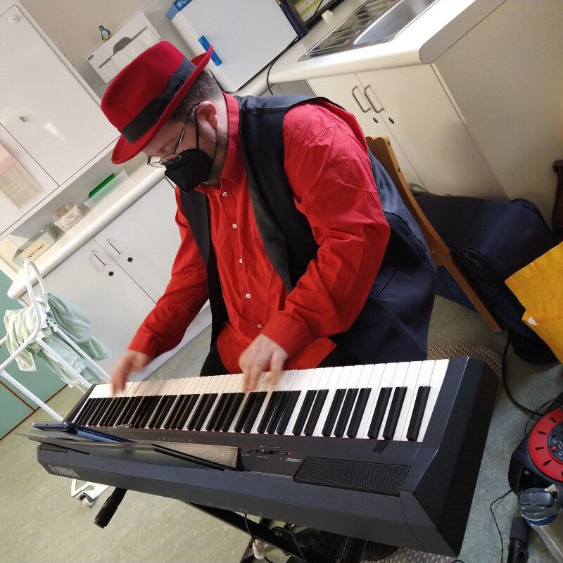 Christopher Lydon performing solo piano in a hospital setting
